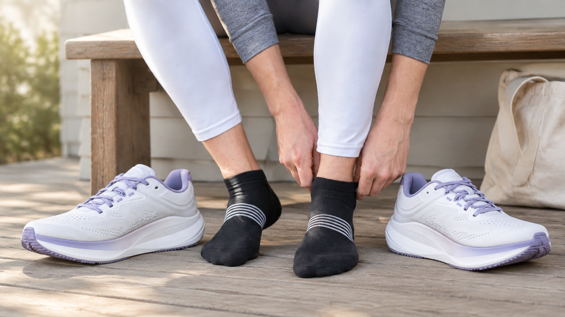 Runner adjusts black socks beside white and lavender Altra shoes on a porch