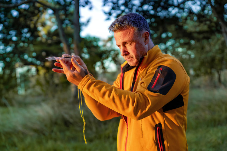 Man using a compass in the woods