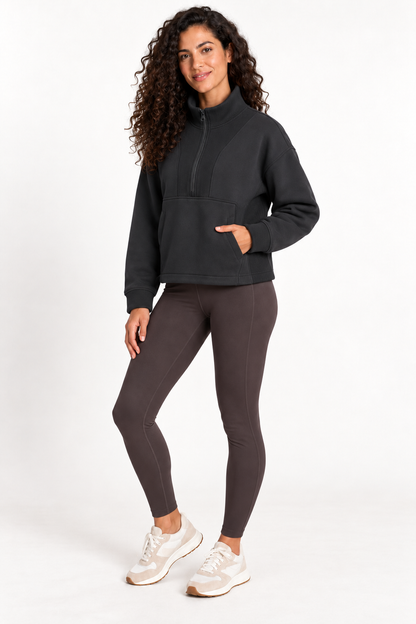 Three-quarter front view of a model wearing the Grace Fairhope Boxy Quarter Zip in Black