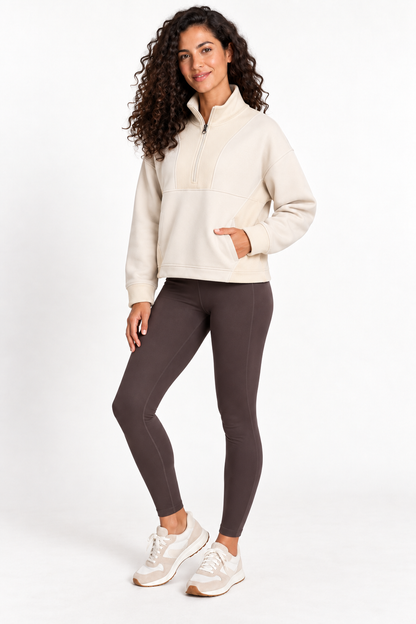 Three-quarter front view of a model wearing the Grace Fairhope Boxy Quarter Zip in ivory