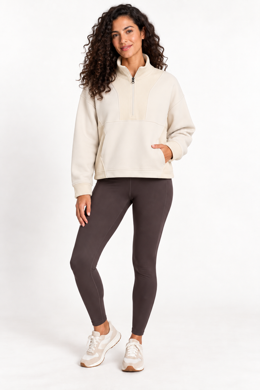 Model wearing the Grace Fairhope Boxy Quarter Zip in ivory with leggings and sneakers
