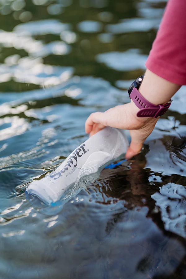 Filling the CNOC bottle from a lake for Sawyer Squeeze filtration