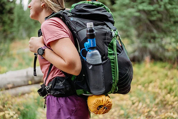 Hiker carrying Sawyer Squeeze and CNOC filtration system