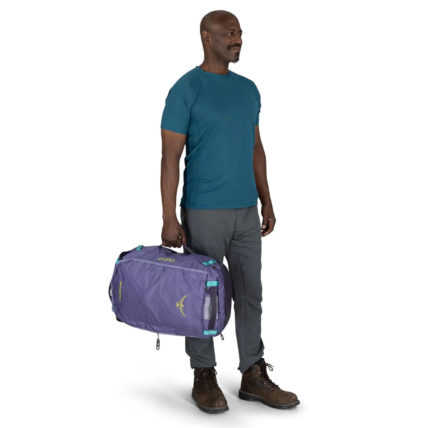 Man carrying Osprey Transporter Duffel 40 in Euphoria Purple by side handle