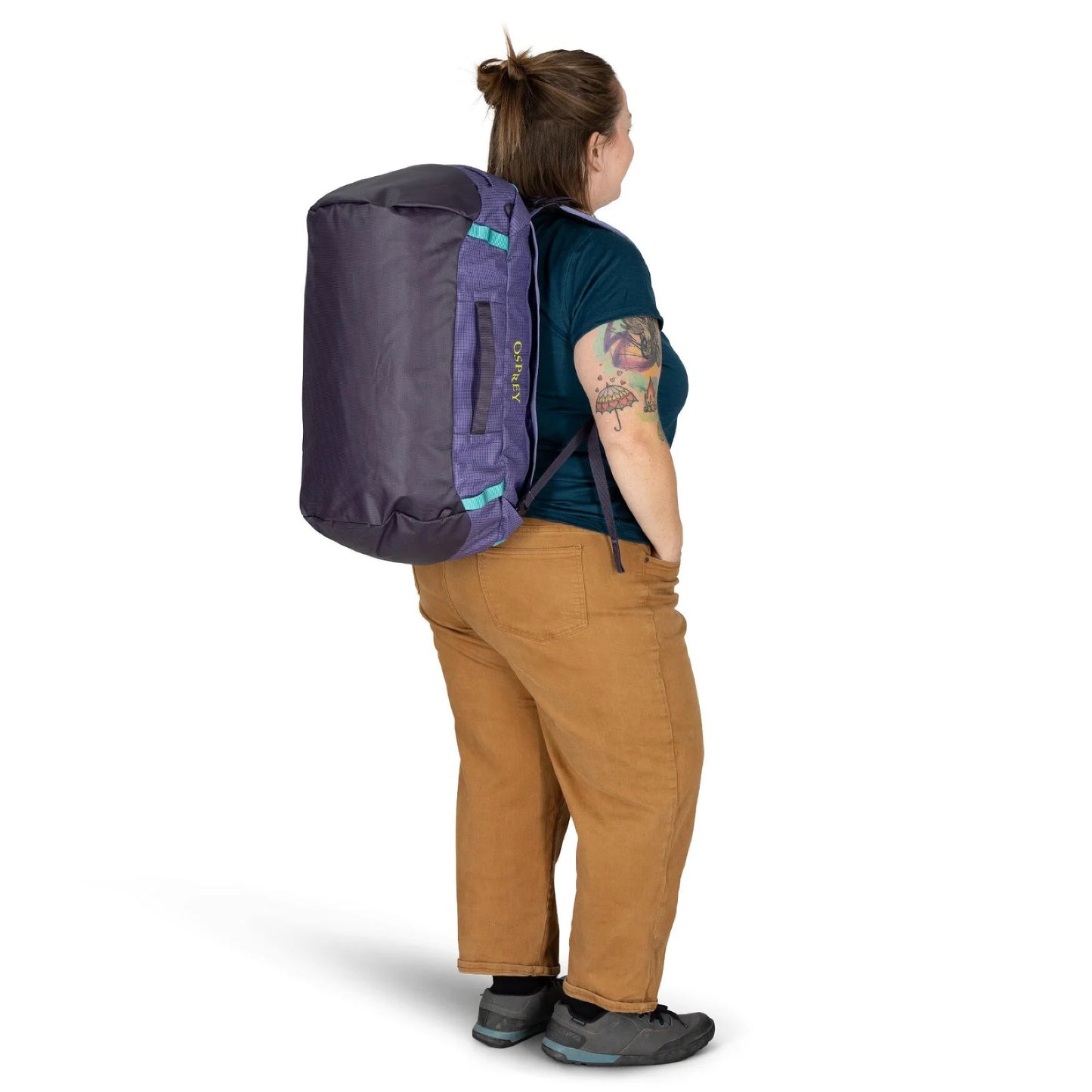Rear view of woman carrying Osprey Transporter Duffel 40 Euphoria Purple in backpack mode