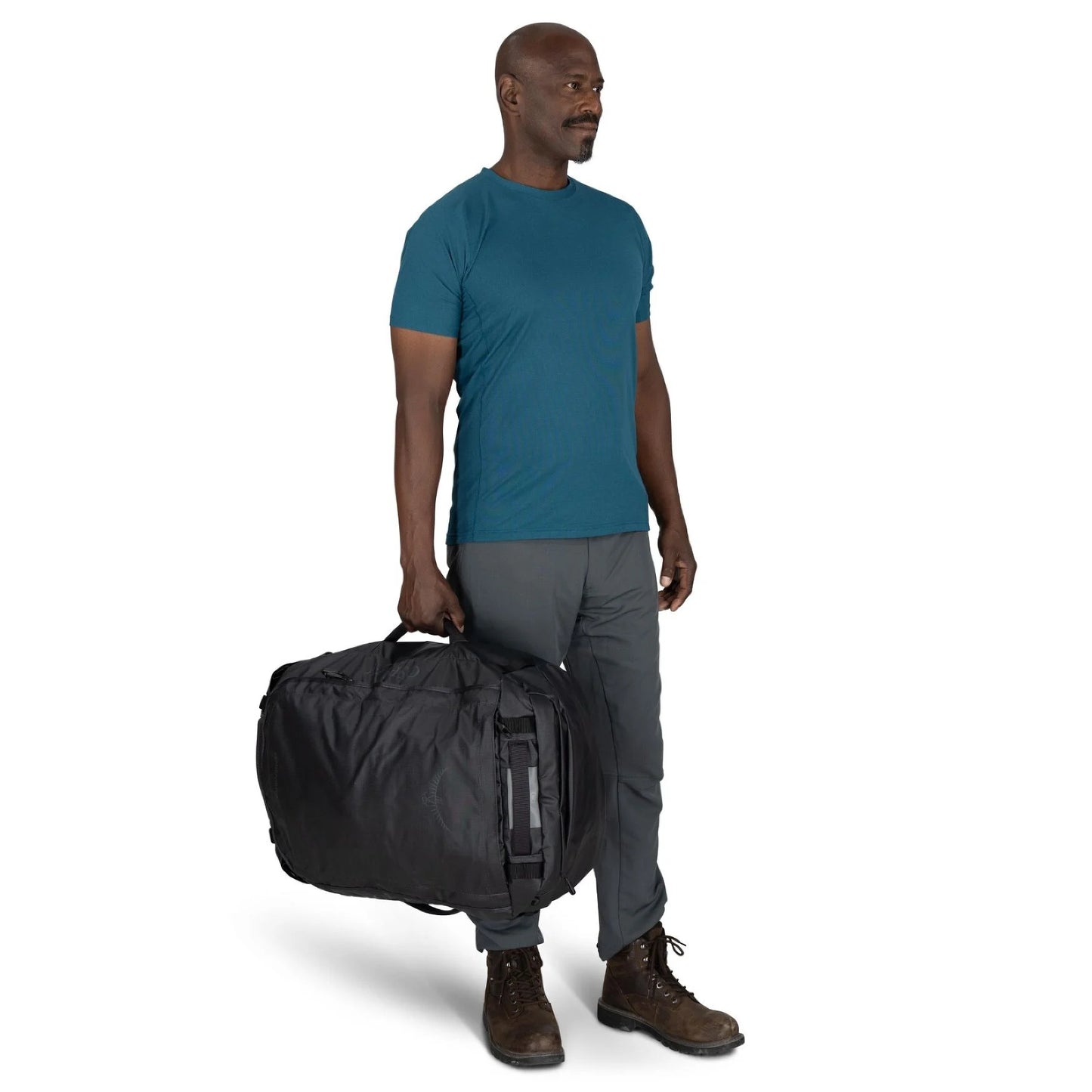 On-Body Side Carry (Front View) – Male model carrying the Osprey Transporter Duffel 65 in Raven Black by hand for scale.
