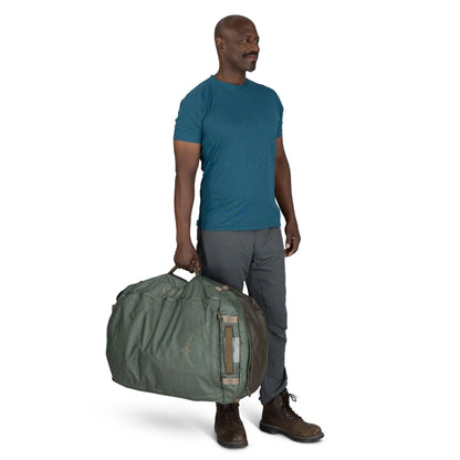 Man carrying Osprey Transporter Duffel 95 in Pine Leaf Earl Grey by side handle.