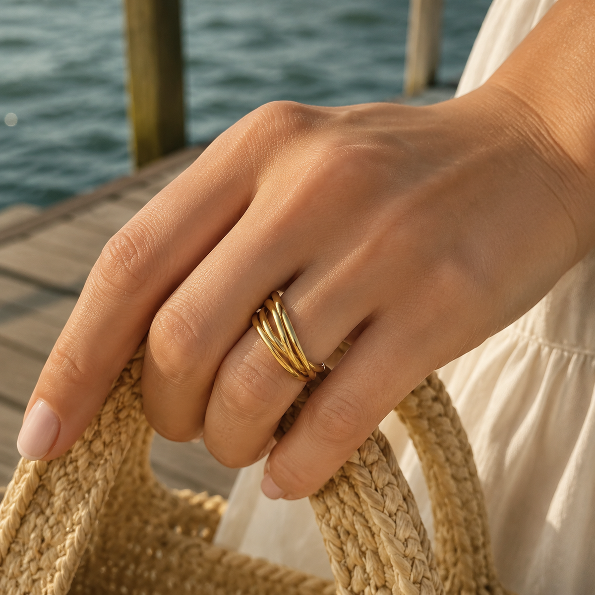 Woman wearing the Willow + Wren Everly Gold Interlocking Ring by the Mobile Bay waterfront