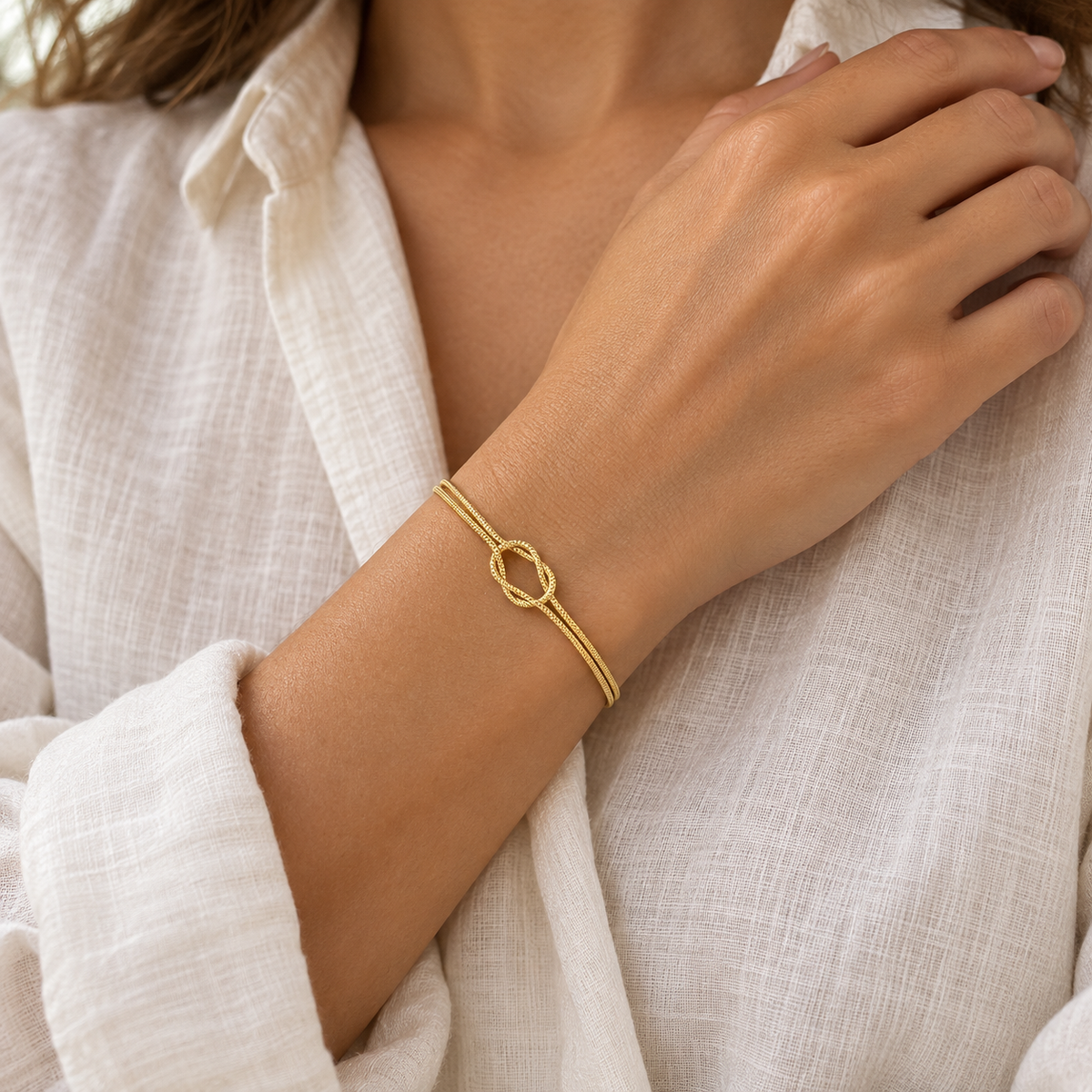 Gold Willow & Wren Double Strand Knot Bracelet shown on a woman's wrist, styled image